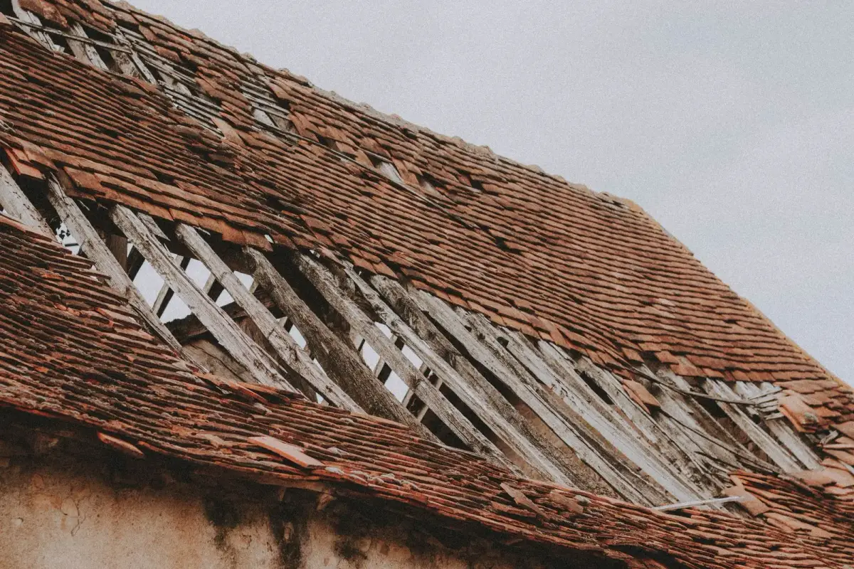 Old roof with broken, weathered shingles