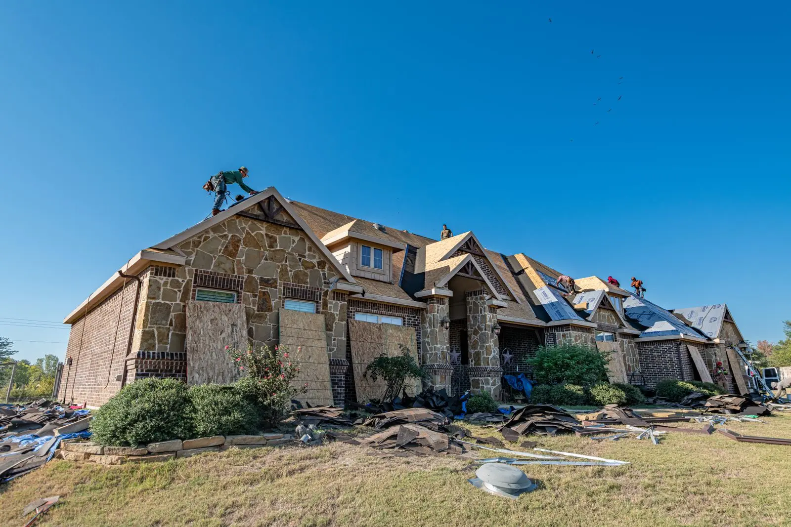 Brick Texas home with its roof partly torn off during a replacement