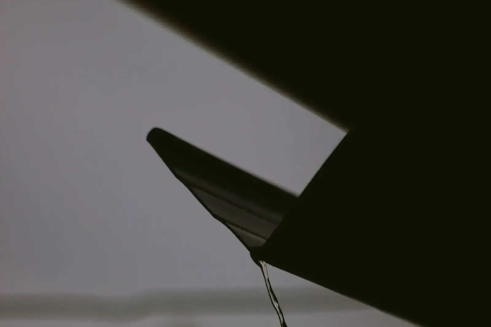 Rainwater dripping from a roof edge
